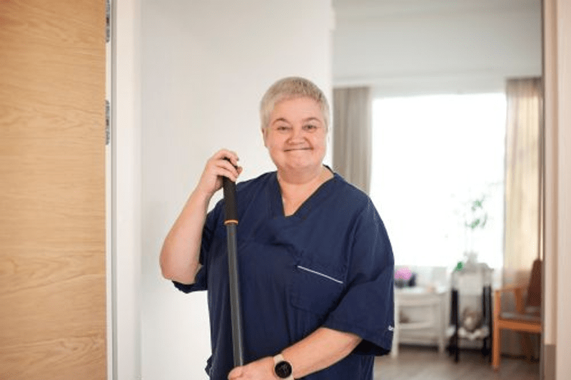 Reija hymyilee kameralle työvaatteissa