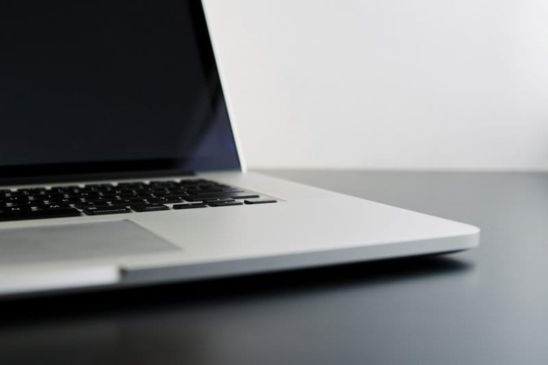 silver laptop computer on black table