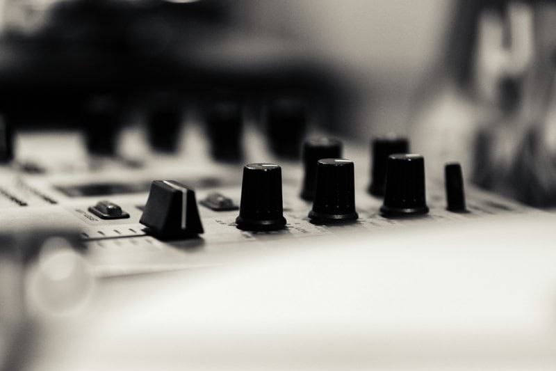 A close up of a sound board with many knobs