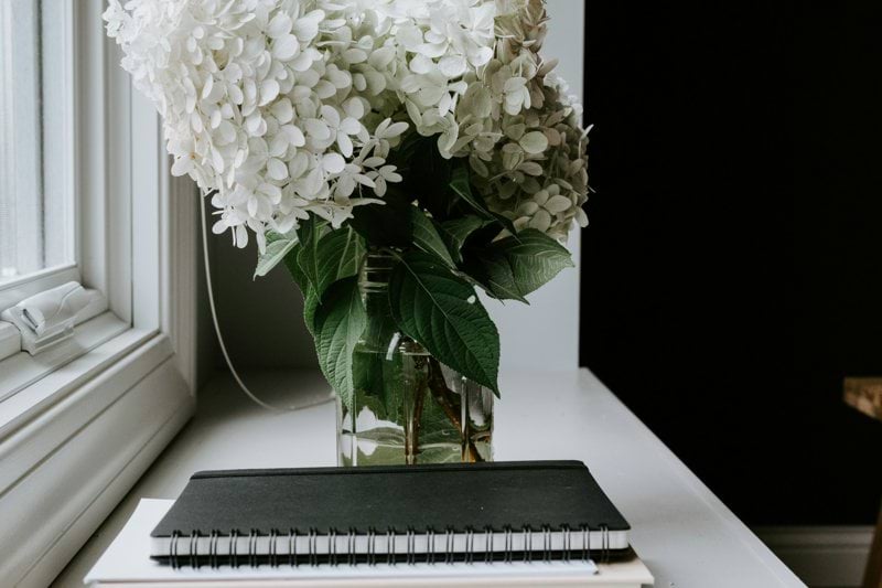 A vase filled with white flowers sitting on top of a table