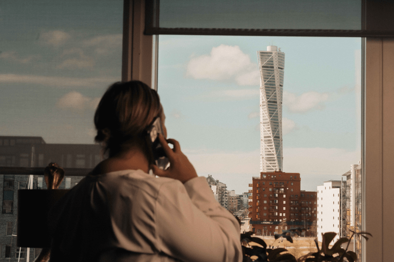 Kvinna talar i telefon och blickar ut över Turning Turso