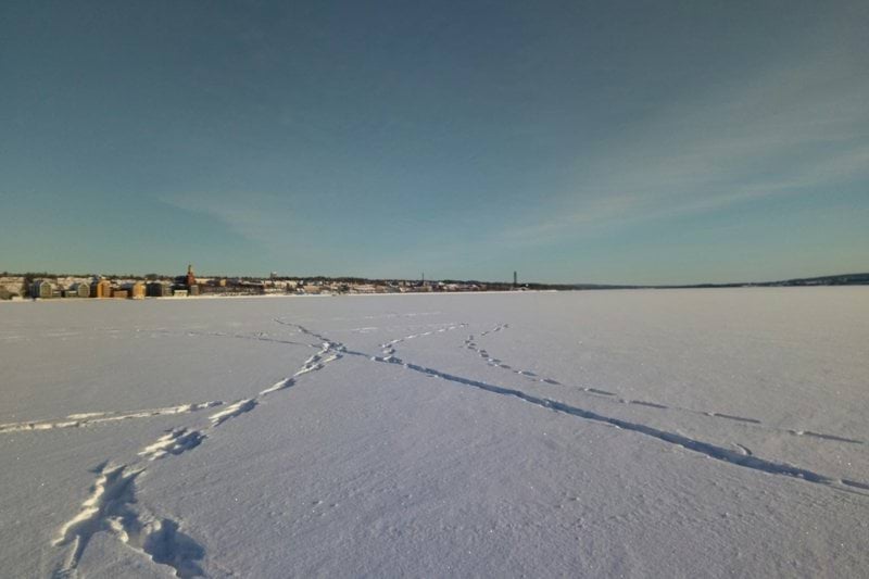 people walking on snow covered field under blue sky during daytime