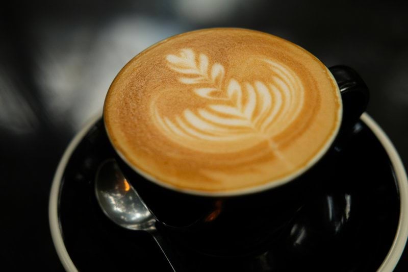 coffee in black ceramic mug on saucer