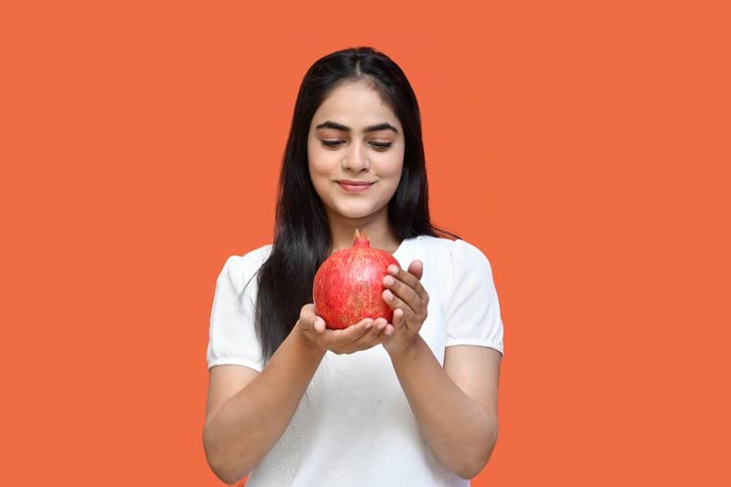a woman holding a red apple