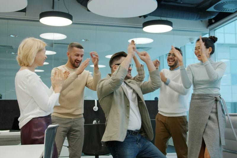 Diverse group of colleagues celebrating success in office