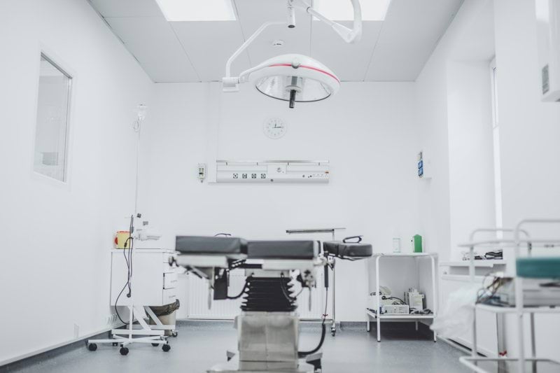 black and white hospital bed in the middle of interior building
