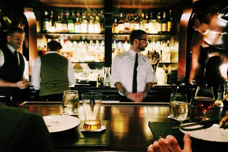 bartender standing beside table