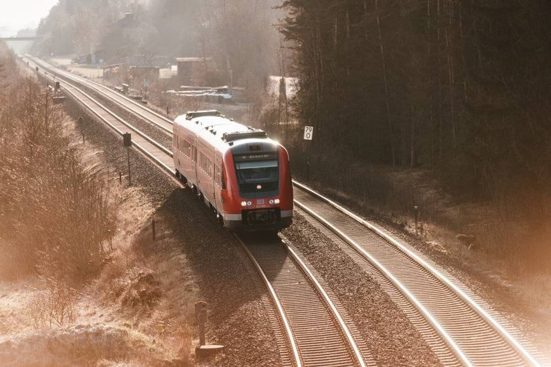 red and white train on rail road during daytime
