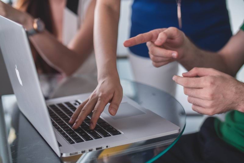 person touching and pointing MacBook Pro