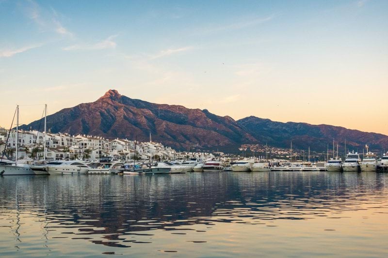 white boats on sea near mountain during daytime