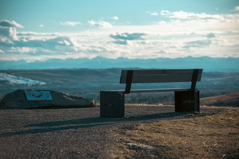 A bench sits on a hill overlooking the view.