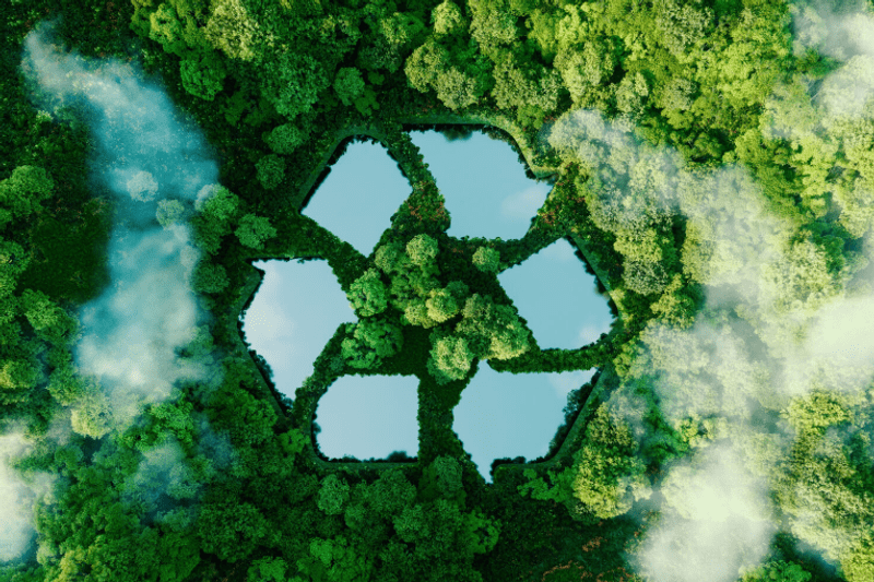 Vue aérienne conceptuelle d'une forêt dense au centre de laquelle des étendues d'eau forment le symbole universel du recyclage