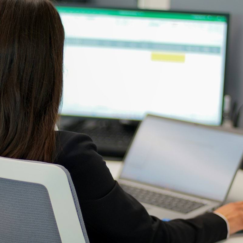 a woman sitting in front of a laptop computer