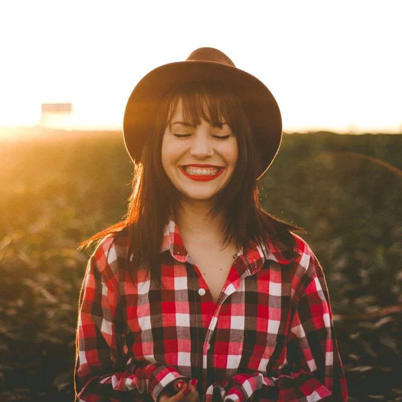 golden hour photography of woman in red and white checkered dress shirt