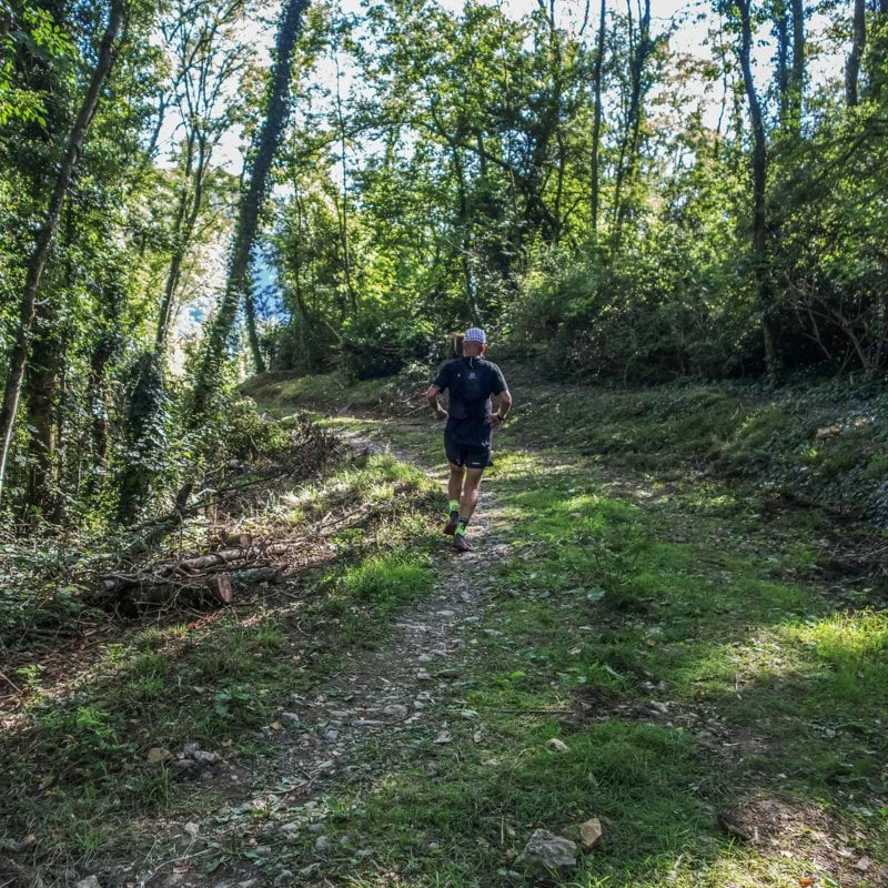 Man running on a forest path during the day