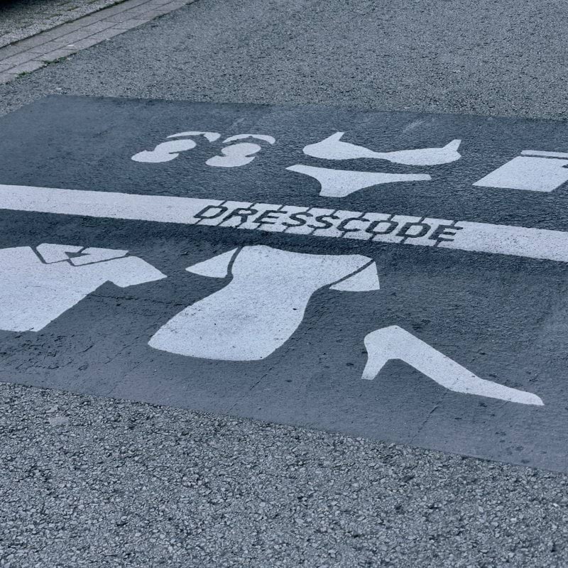 Dresscode sign on the streets. Depending on what side of the line you are, you should me dressed less naked.