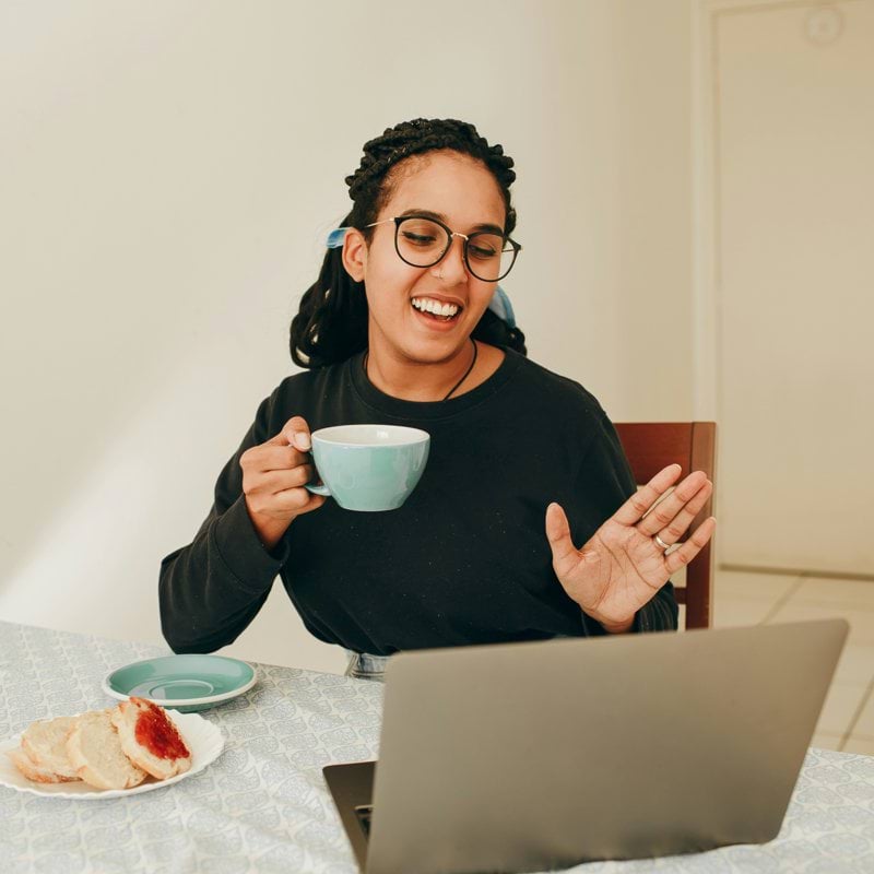 woman in black long sleeve shirt holding white ceramic mug