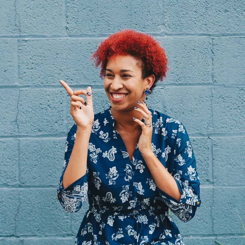 woman smiling while pointing on her right side
