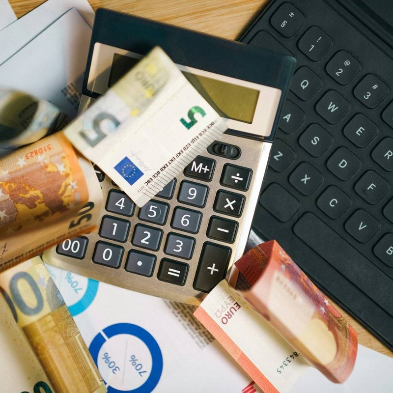A calculator sitting on top of a pile of money