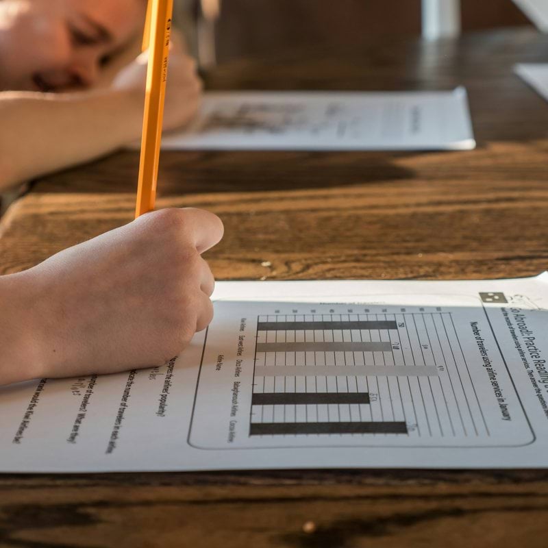 person writing on white paper