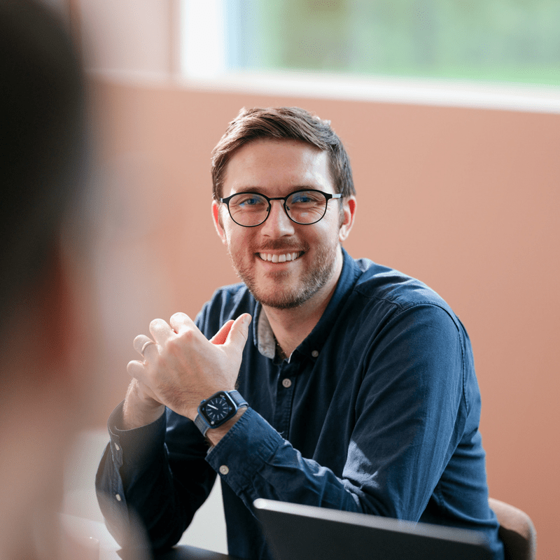 Mann smiler, møtebord