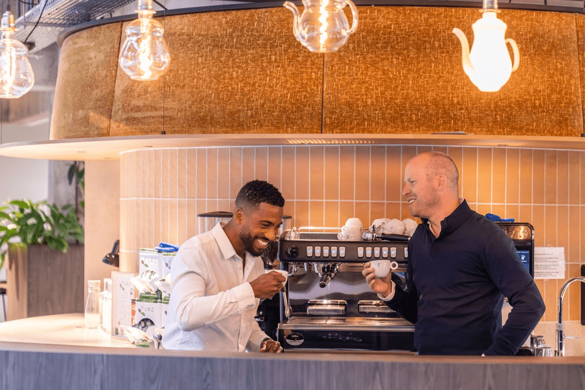 Two colleagues having coffee at the bar in our Eindhoven office