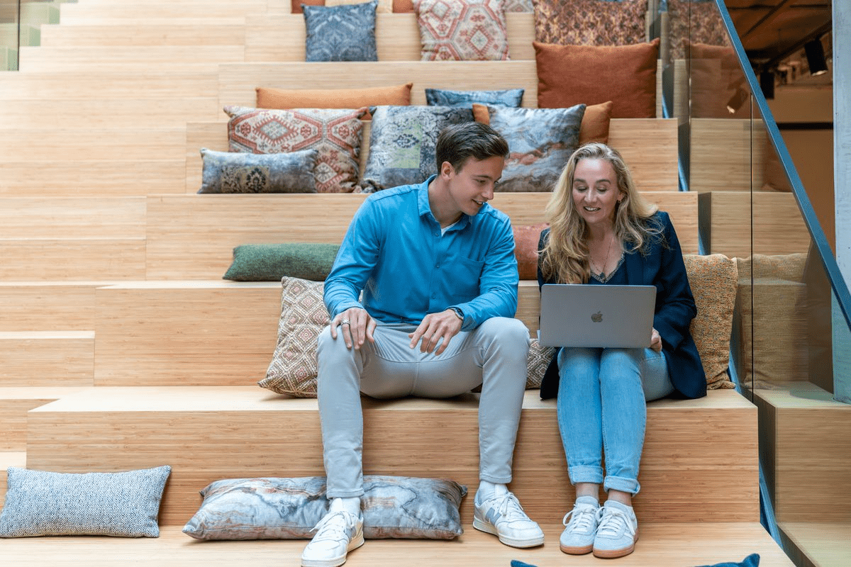Two colleagues working together on the stairs of our Eindhoven office