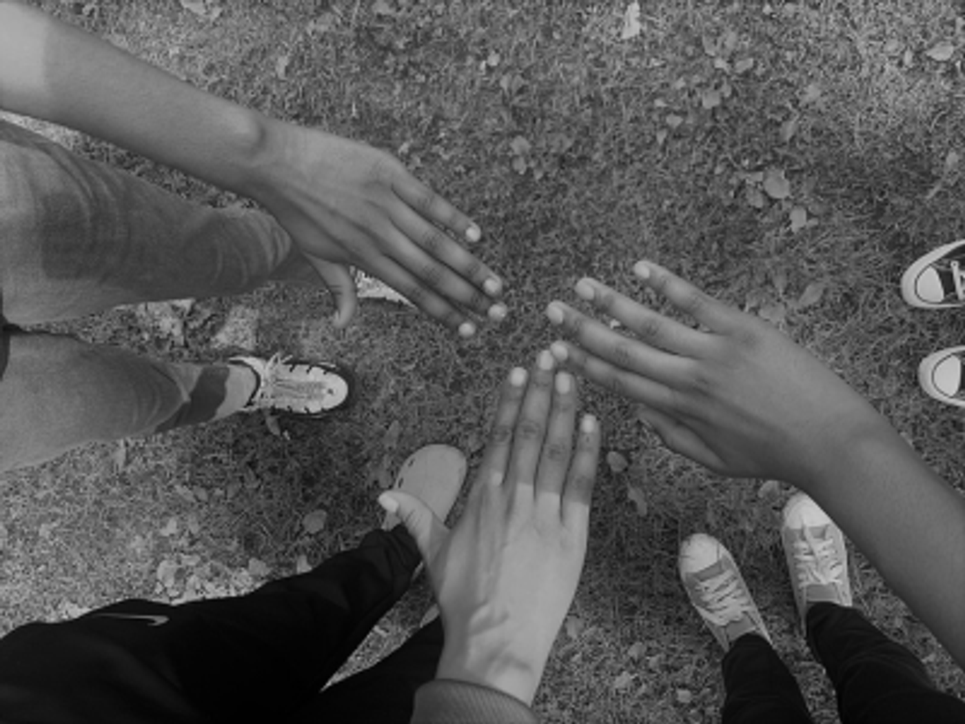 Three hands reaching together in a circle