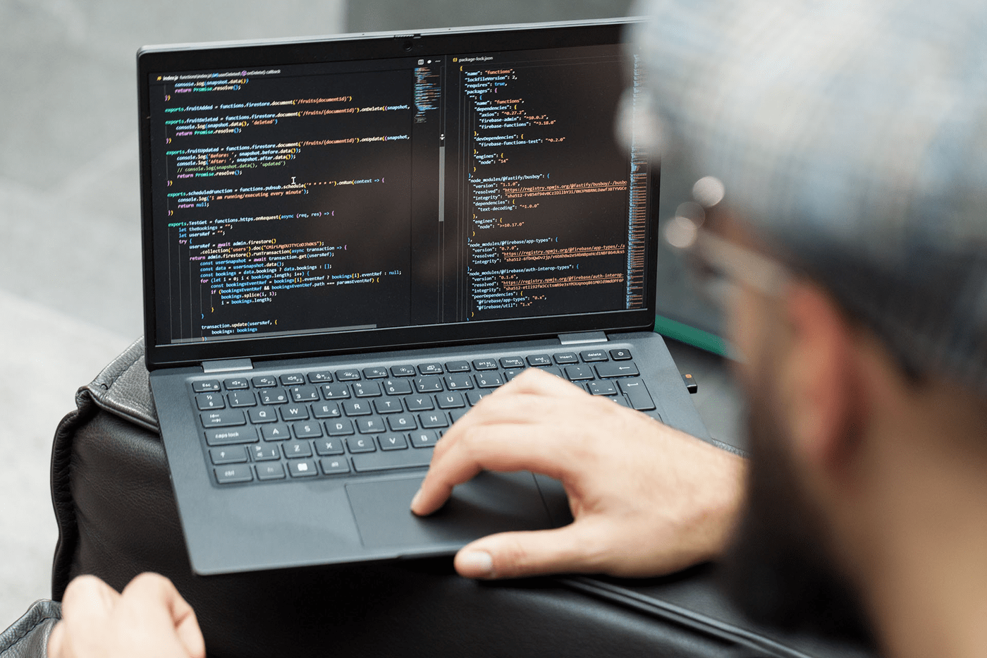 Prson working on a laptop displaying computer code