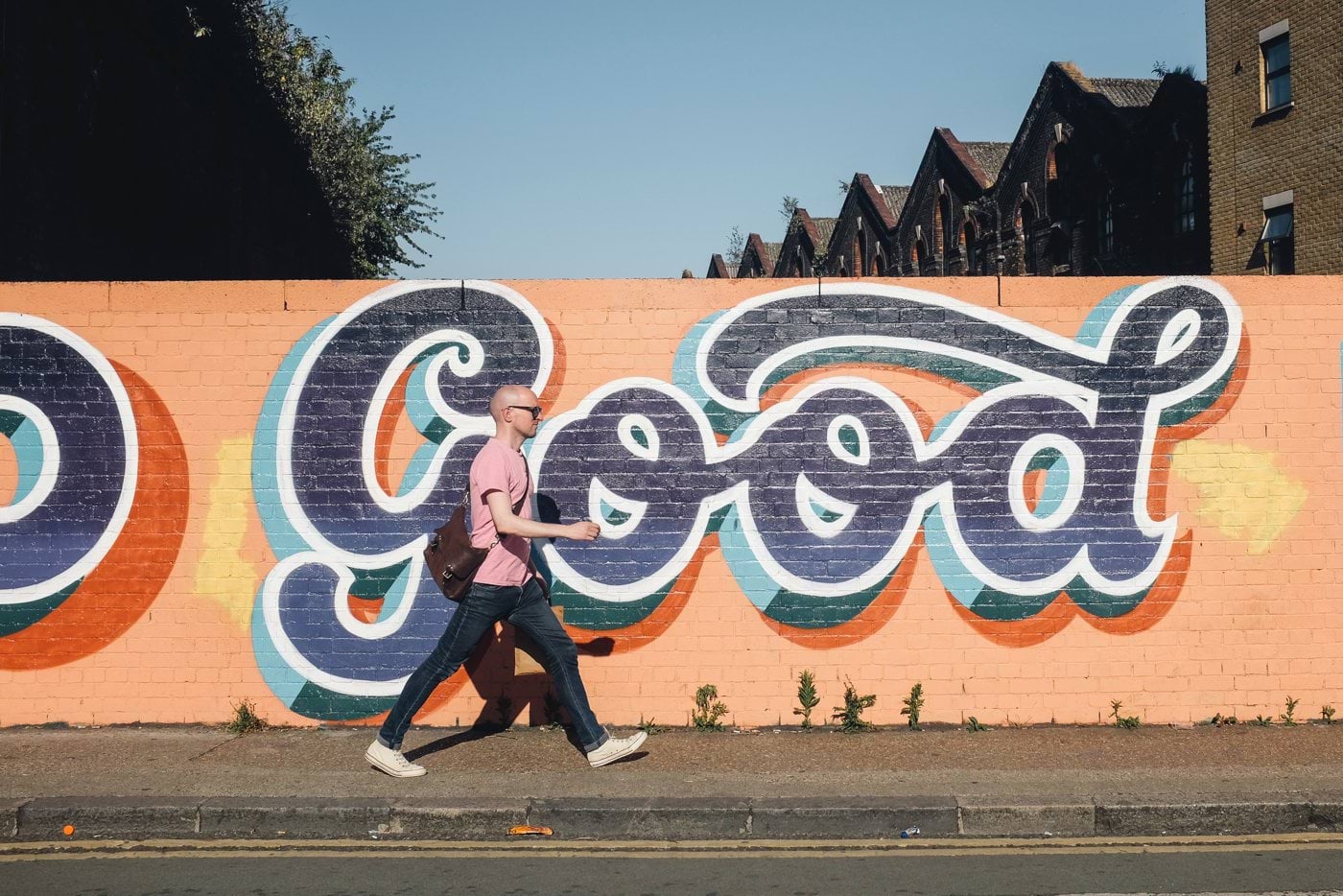 man walking beside graffiti wall