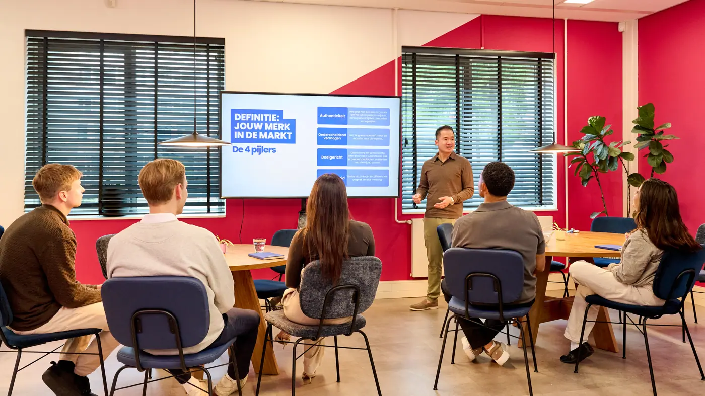 Een groep consultants krijgt training over branding en marketing tijdens hun traineeship in amsterdam