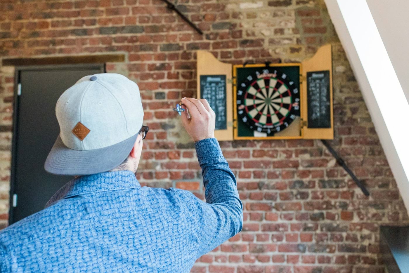 man in blue dress playing dart