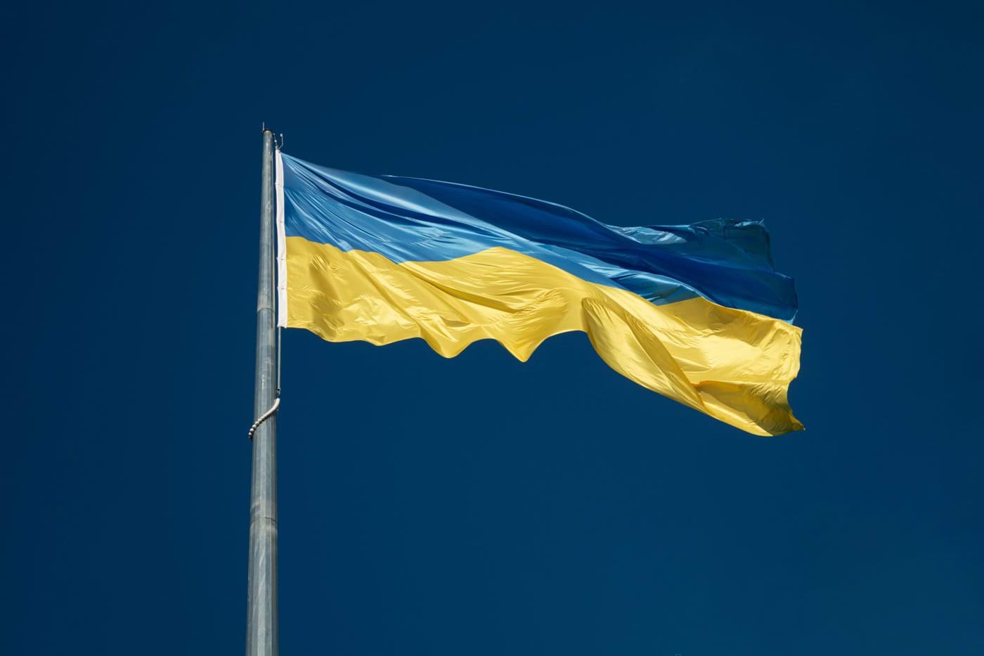 the flag of ukraine is flying high in the sky