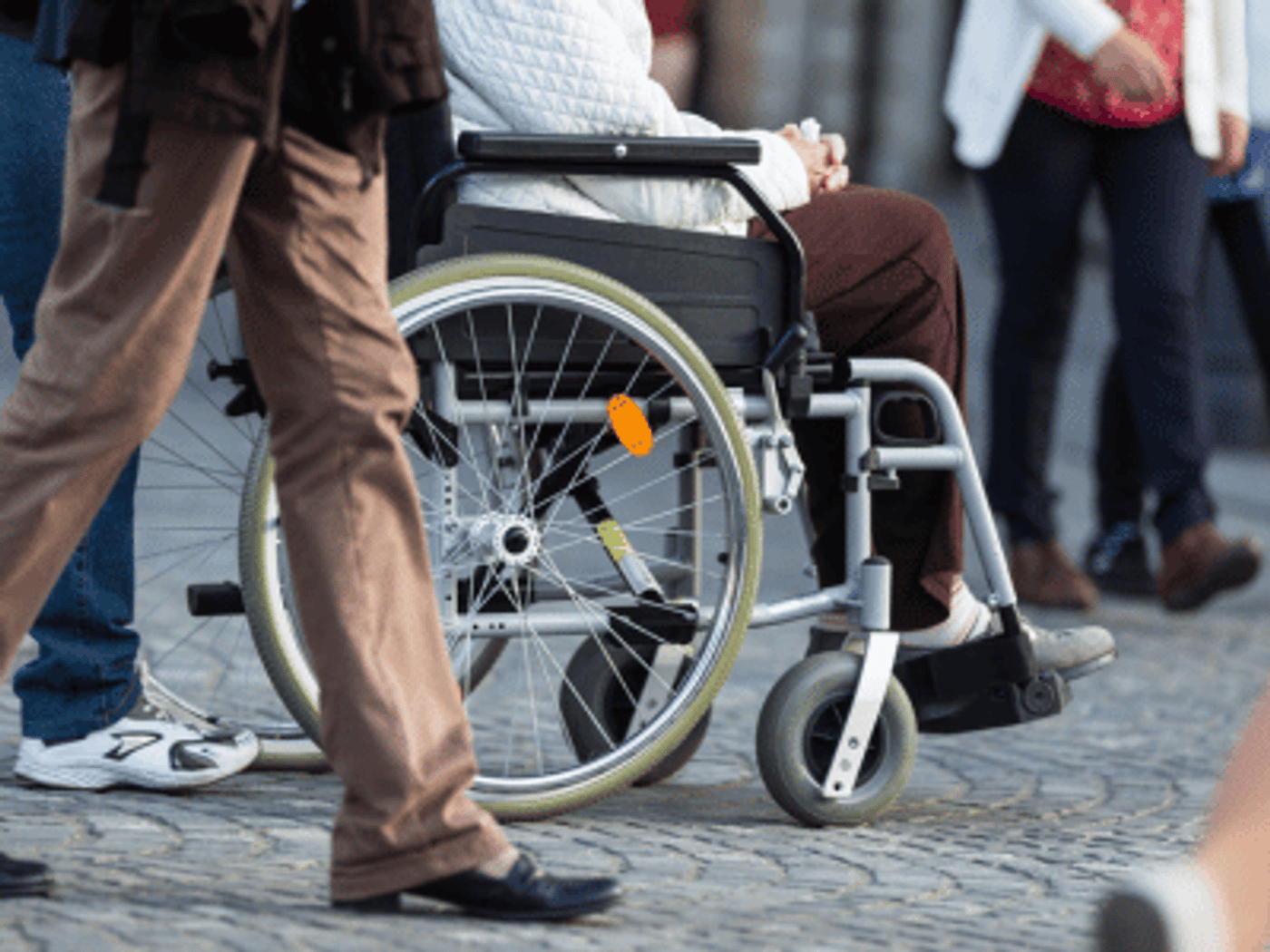 Person in a wheelchair on a cobbled street