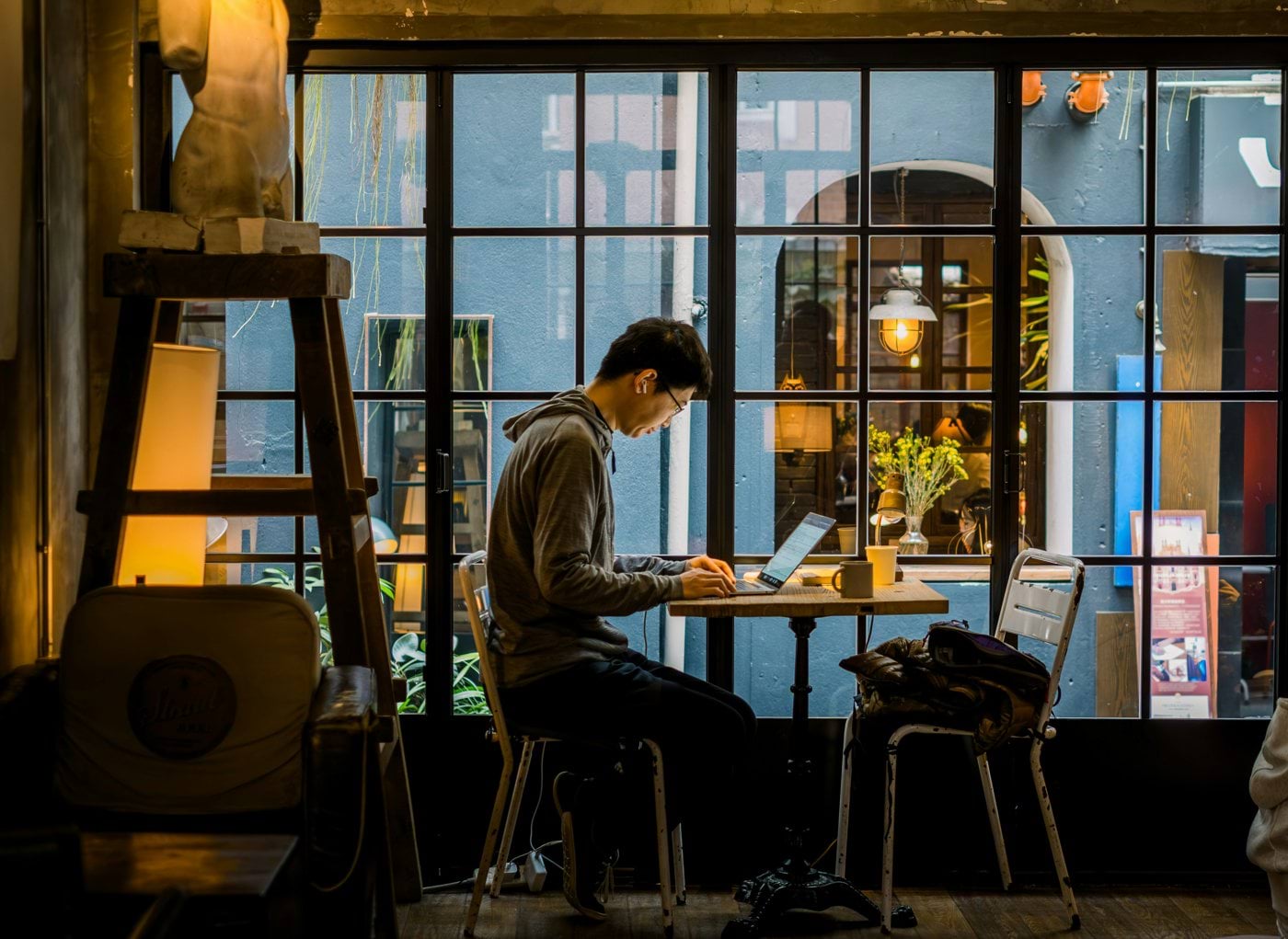 Man working on laptop in a cafe by the window