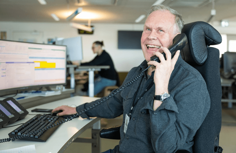 Manlig medarbetare som skrattar och pratar i telefon