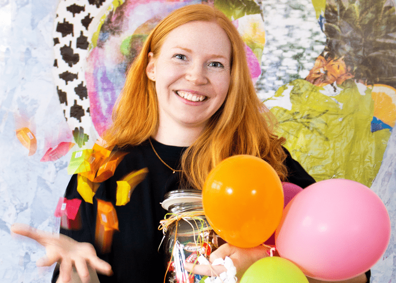 Human Resources Mitarbeiterin hält Luftballons und Süßigkeiten